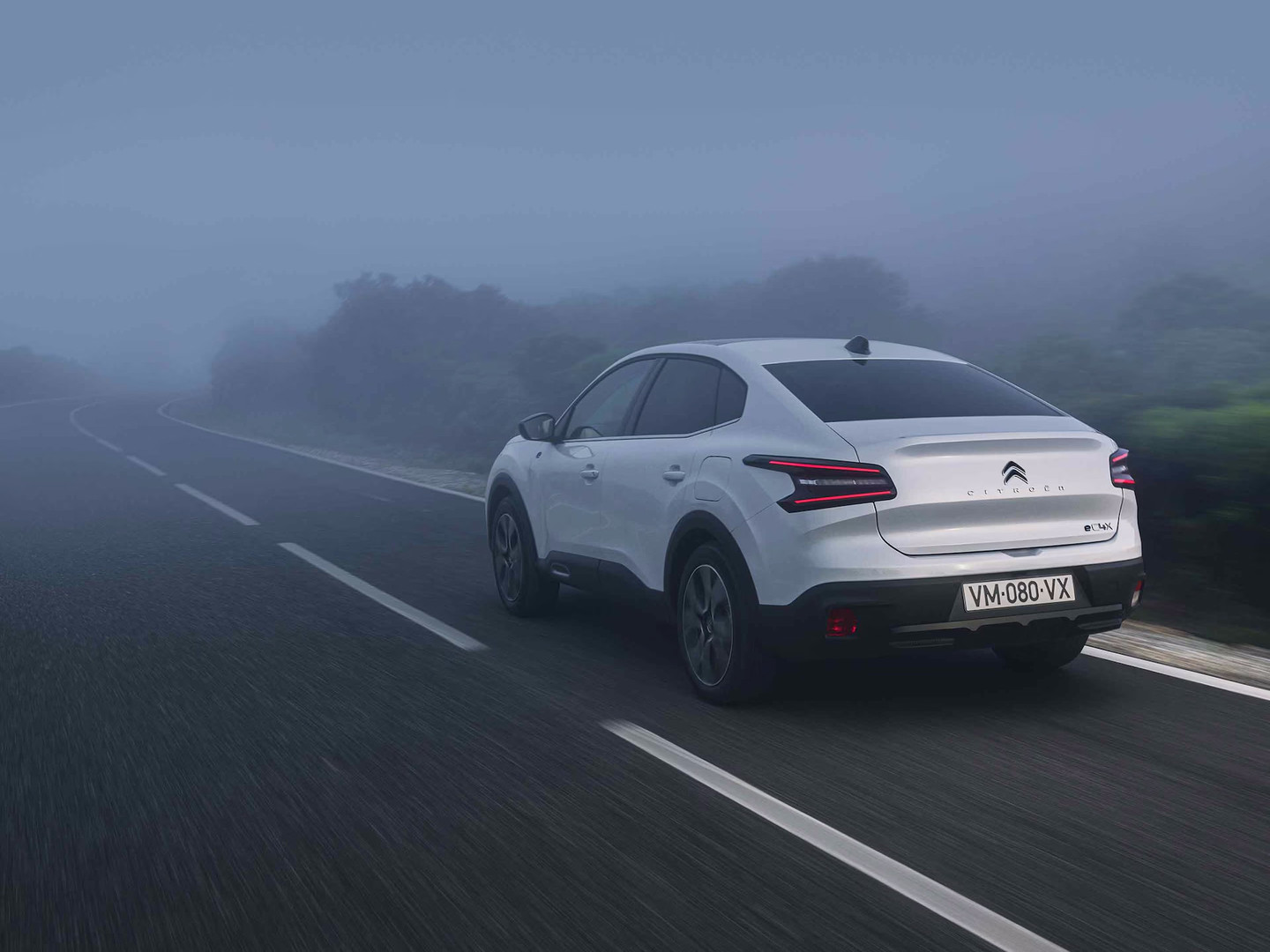 Citroën ë-C4 X Elettrica che percorre una strada nella nebbia